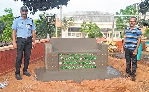 The benches are deliberately designed to show the green, yellow and white bottoms of the bottles, displaying their non-organic origins.