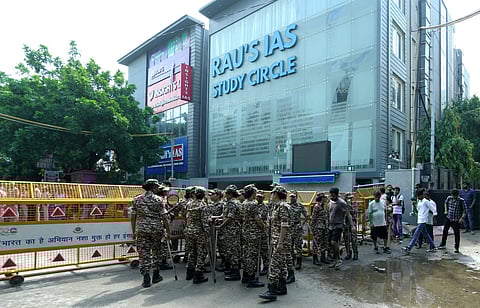 Security personnel stand guard near a UPSC exam coaching centre after three civil services aspirants died when the basement of the coaching centre was flooded following heavy rain, in New Delhi, Sunday, July 28, 2024.