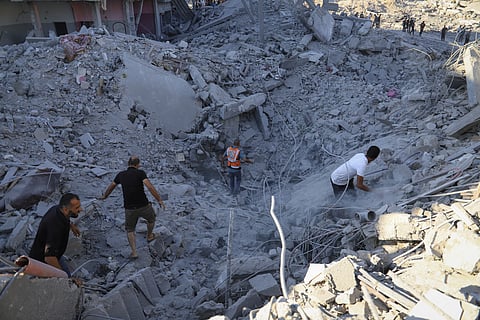 Palestinians search for bodies and survivors in the rubble of a residential building destroyed in an Israeli airstrike in Khan Younis, Gaza Strip, Wednesday, July 3, 2024.