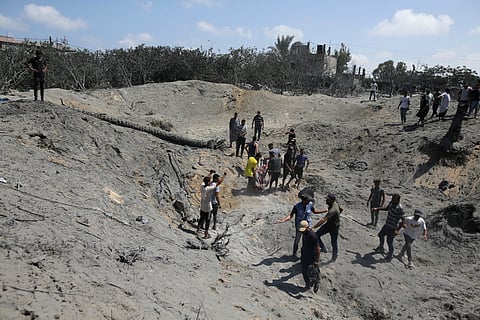 Palestinians search for bodies and survivors in a site hit by an Israeli bombardment on Khan Younis, southern Gaza Strip