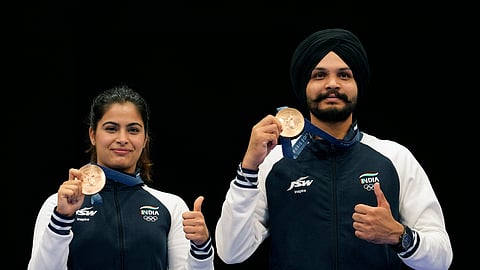 India's Manu Bhaker, left, and Sarabjot Singh pose for a photograph after winning the bronze medal in the 10m air pistol mixed team event at the 2024 Summer Olympics, Tuesday, July 30, 2024