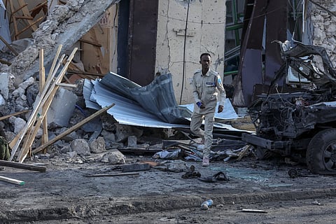 A Somalian police officer looks at debris and destruction at a cafe in Mogadishu on July 15, 2024 following a car bomb blast where five people were killed where football fans were watching the Euro 2024 final late on July 14, 2024.