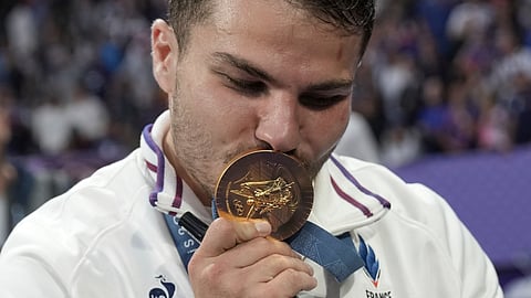 Antoine Dupont of France kisses his gold medal as he celebrates after France won the men's Rugby Sevens gold medal at the 2024 Summer Olympics.