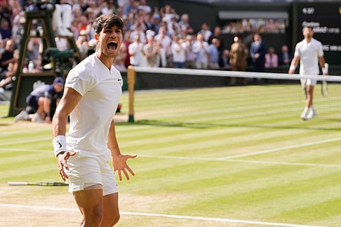Carlos Alcaraz of Spain reacts after winning a point against Novak Djokovic of Serbia during the men's singles final at the Wimbledon tennis championships in London, Sunday, July 14, 2024.