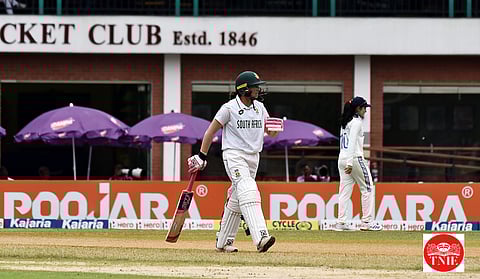 Sune Luus with an ad board that resembles Cheteshwar Pujara's name on the background