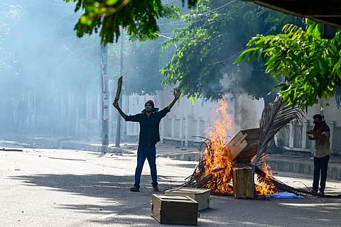 Students set wood on fire as they protest against quotas in government jobs at Dhaka University.