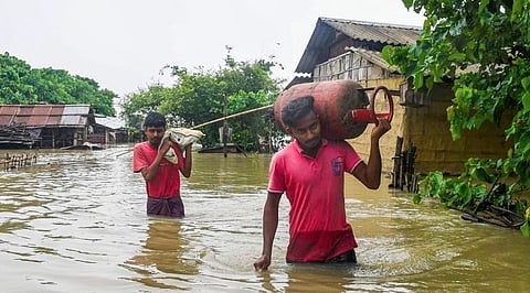 Villagers wade through a flood affected area, at Mayong village in Morigaon district, Tuesday, July 2, 2024.
