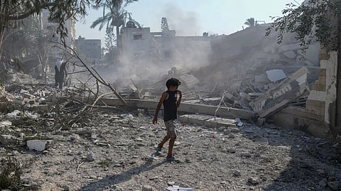 A Palestinian boy walks past the rubble of a school destroyed in an Israeli airstrike on Deir al-Balah, central Gaza Strip, Saturday, July 27, 2024