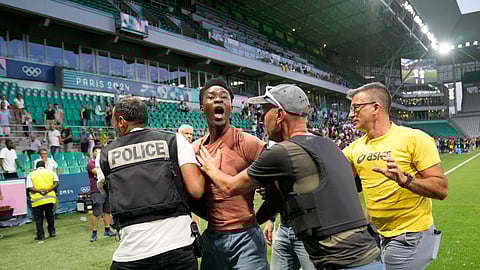 Security guards grab a pitch invader during the men's Group A soccer match between the United States and Guinea at Geoffroy-Guichard Stadium during the 2024 Summer Olympics, Tuesday, July 30, 2024, in Saint-Etienne, France.