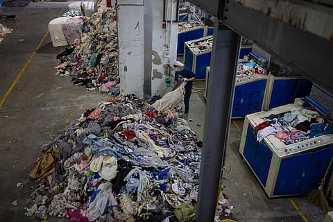 A worker feeds discarded textiles to a shredding machine at the Wenzhou Tiancheng Textile Company, one of China's largest cotton recycling plants in Wenzhou in eastern China's Zhejiang province.