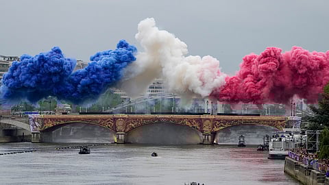 Ceremonial smoke in the colors of the France flag appear over the Seine River in Paris, France, during the opening ceremony of the 2024 Summer Olympics.