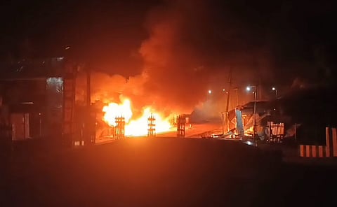 Smoke and flame out after shops and houses were set on fire following the death of a yough, in Gandacherra subdivision of Dhalai district, Tripura, Friday night, July 12