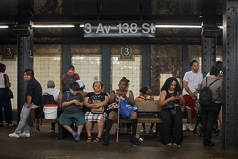 People wait for the train on a hot day, Friday, June 21, 2024, in the Bronx Borough of New York.