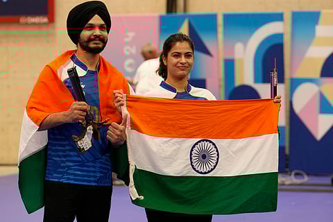 India's Manu Bhaker, right, and Sarabjot Singh celebrate after winning the bronze medal in the 10m air pistol mixed team event at the 2024 Summer Olympics, Tuesday, July 30, 2024, in Chateauroux, France.