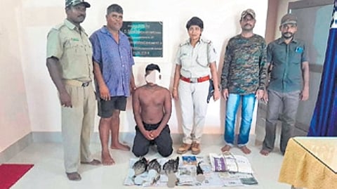The accused with the bird carcasses and seized materials