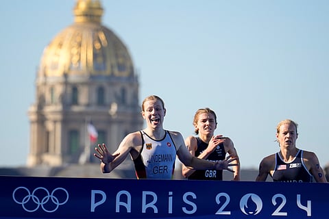 Germany's Laura Lindemann, lef, Britain's Beth Potter, center, and Taylor Knibb, of the United States, right, run to the finish line at the end of the mixed relay triathlon at the 2024 Summer Olympics