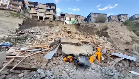 An escavator crushed under the debris after a building collapsed at Kabaddi Nalla, in Kargil, Saturday, Aug. 3, 2024.