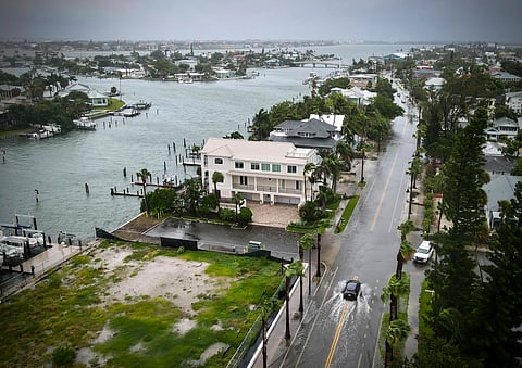 A driver negotiates a flooded street as Tropical Storm Debby passes just to the west of the Tampa Bay, Fla., region, Sunday, Aug. 4, 2024.