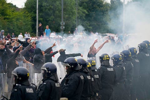 Police officers face protesters during an anti-immigration demonstration outside the Holiday Inn Express in Rotherham, England, Sunday Aug. 4, 2024.