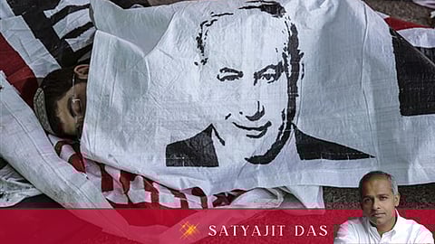 An Israeli settler sleeps under a banner of Israeli Prime Minister Benjamin Netanyahu, in the Jewish settlement of Beit El after a night stand off with police, near the West Bank town of Ramallah. Many of Israel's problems are the making of their 'Mr. Security'.