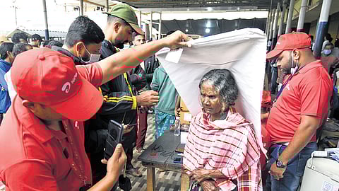 Network service providers taking photos of relief camp inmates for issuing new SIM cards and mobile phones.