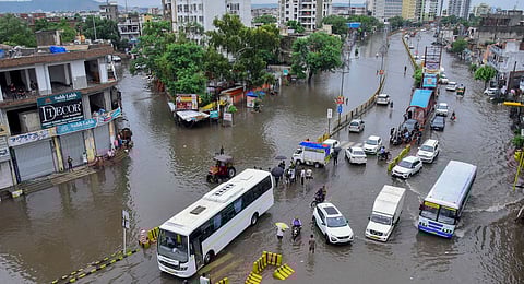 Commuters wade through a waterlogged road after rains, in Jaipur, Thursday, August 1, 2024.