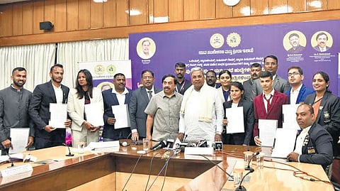 Chief Minister Siddaramaiah with sportspersons from the state after handing them offer letters from various departments, in Bengaluru on Sunday