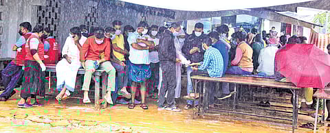 Volunteers and relatives of those missing in landslides wait outside the family health centre at Meppadi, where the bodies of the deceased are brought to