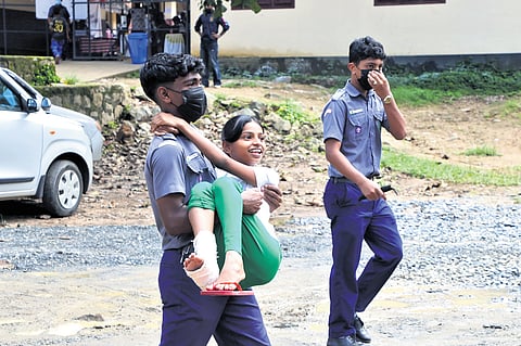 Boy scout Abhinav carries Shahana, who injured her legs in the landslide, for medical check-up at the relief camp opened at
SDM LP School, Kalpetta, Wayanad, on Tuesday
