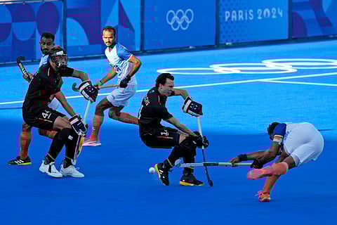 India's Harmanpreet Singh, right, shoots from a penalty corner during the men's semifinal field hockey match between Germany and India during the 2024 Summer Olympics, Tuesday, Aug. 6, 2024, in Colombes, France.