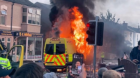 A police van buns as and unruly crowd clashed with police, Tuesday, July 30, 2024, in Southport, northwest England.