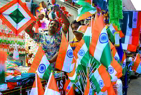 A shopkeeper displaying National flag ahead of Independence Day celebrations at Sikkim