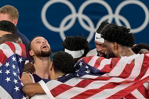 United States' Stephen Curry (4) reacts with his team after winning a men's gold medal basketball game against France at Bercy Arena at the 2024 Summer Olympics.