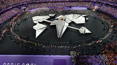 Flag bearers surround the stage during the 2024 Summer Olympics closing ceremony at the Stade de France.