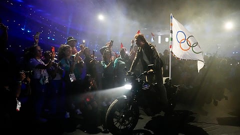 Tom Cruise rides a motorbike with the Olympic flag attached during the 2024 Summer Olympics closing ceremony at the Stade de France.