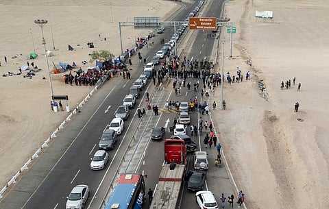 Stranded Venezuelan migrants block the border crossing in Tacna, Peru, after Chilean authorities returned them to Peru where authorities won't let them travel further into the country, April 29, 2023.