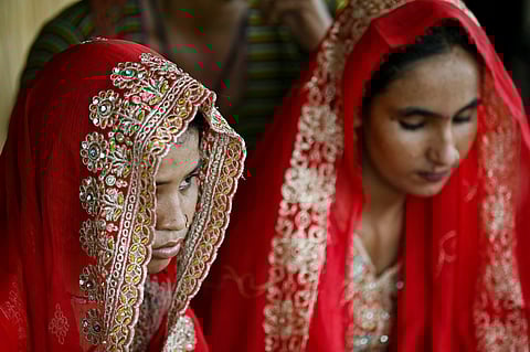 In this photograph taken on August 3, 2024 Shamila (L) and Salma Zameer, monsoon brides who were married underage look on at Khan Muhammad Mallah village, Dadu district in Sindh province.