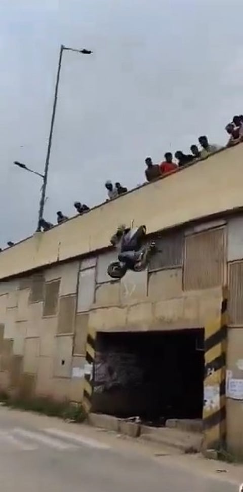 A video grab from the incident where people seen throwing a scooter from the flyover