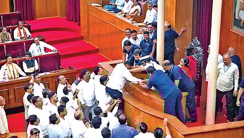 A BJD MLA being supported by colleagues as he tries to climb Speaker’s podium