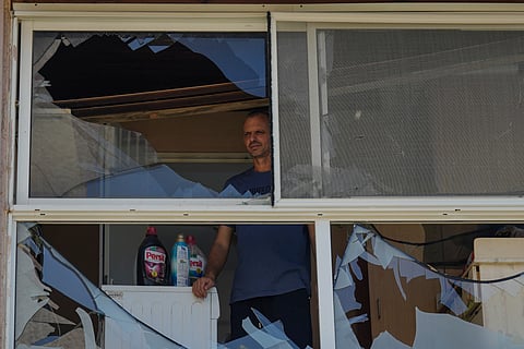 A man looks at a damaged window of a house following an attack from Lebanon, in Acre, north Israel, Sunday, Aug. 25, 2024.