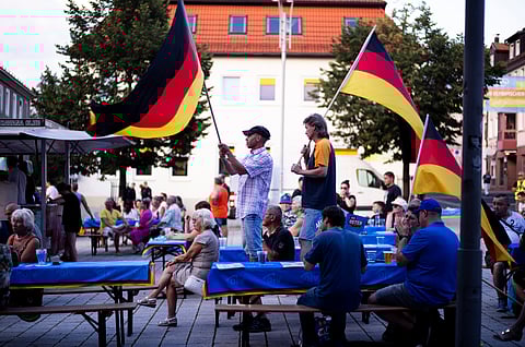 Supporters of the far-right Alternative for Germany party, or AfD, hold German national flags as they attend an election campaign rally of the party for upcoming state elections, in Suhl, Germany.