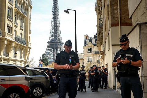 Police officers gather in a street near the Eiffel Tower on the eve of the Paralympic Games opening ceremony in Paris.