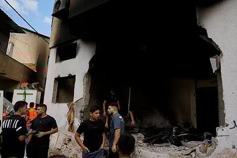 Palestinians stand outside a heavily damaged mosque following an Israeli military operation in the West Bank refugee camp of Al-Faraa.