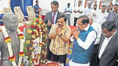 Home Minister Dr G Parameshwara and Karnataka Olympic Association President Dr K Govindaraj pay their respects to the statue of hockey legend Dhyan Chand during the National Sports Day event in Bengaluru on Thursday