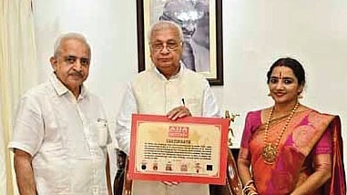 Governor Arif Mohammad Khan presenting the Asia Book of Records certificate and medal to K N Anandakumar and dancer Gayathri Subramanian at a function held at Raj Bhavan in Thiruvananthapuram
