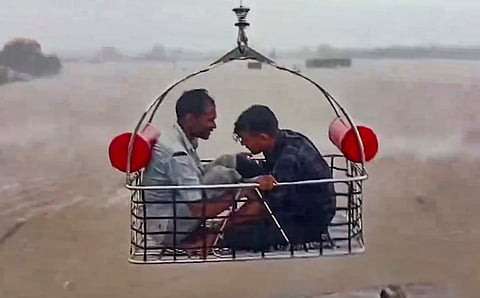 Two people being rescued by an Indian Coast Guard aircraft from a flood-hit area following heavy rainfall, at Devbhumi Dwarka district of Gujarat, Thursday, Aug 29, 2024.