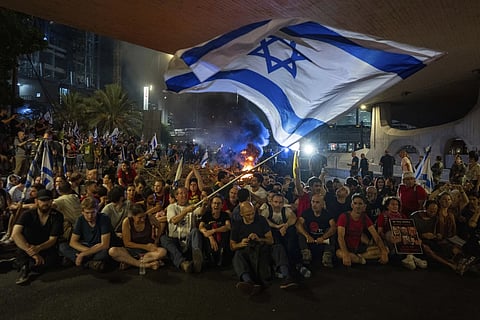 People block a road as they protest, calling for a deal for the immediate release of hostages held in Gaza Strip by Hamas, in Tel Aviv, Israel, Sunday, Sept 1, 2024.