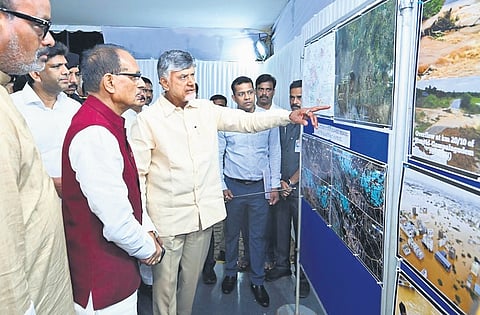 Chief Minister Nara Chandrababu Naidu explains the flood damage to Union Agriculture Minister Shivraj Singh Chouhan at a photo exhibition organised in Vijayawada on Thursday