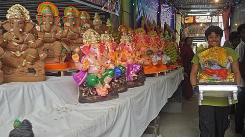A boy buys Ganesh idols in preparation for the Ganesh Chaturthi festival at Malleshwaram in Bengaluru.