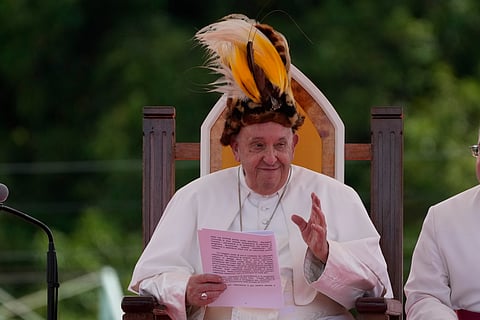 Pope Francis wears a traditional hat during a meeting with faithful in Vanimo, Papua New Guinea.